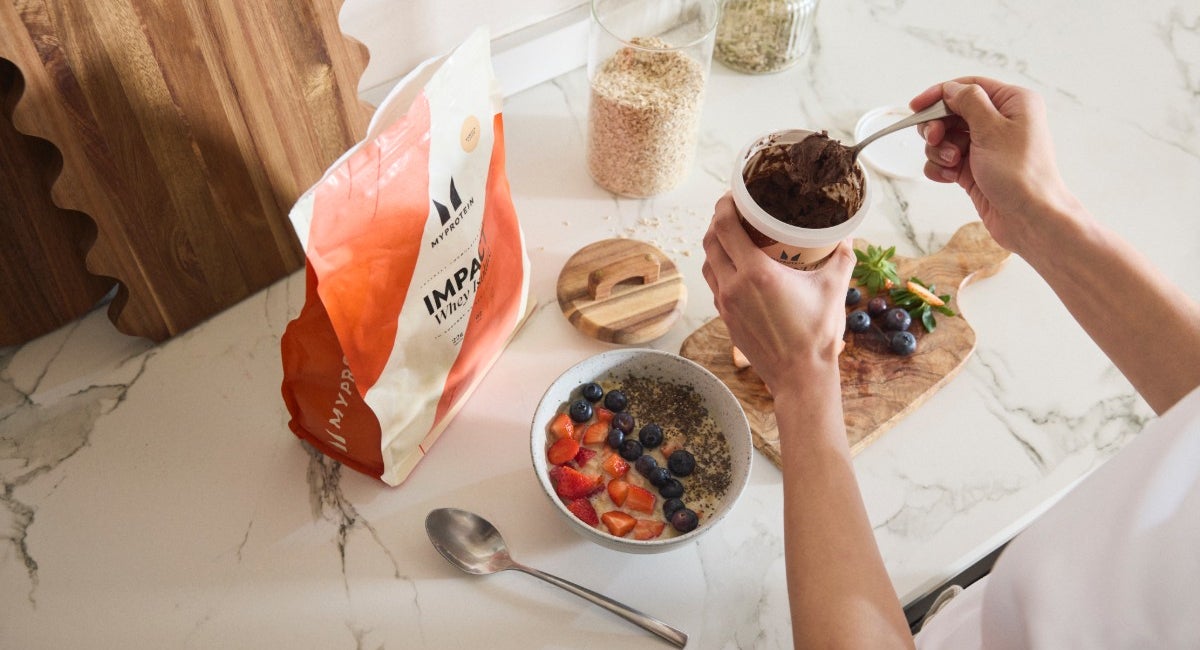 A bag of Myprotein Impact Whey Isolate next to a breakfast bowl topped with berries