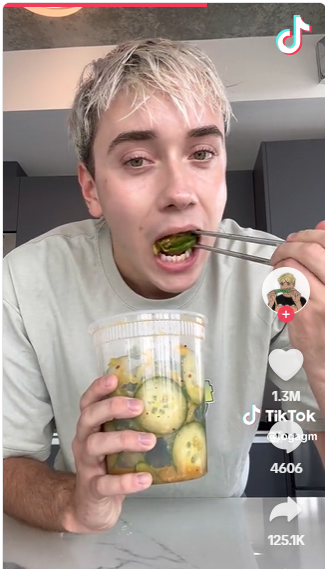 a screenshot of Logan Moffiit’s original cucumber salad video, paused to show the salad in the container as he’s about to take a bite.