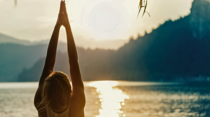 woman doing sun salutations outside