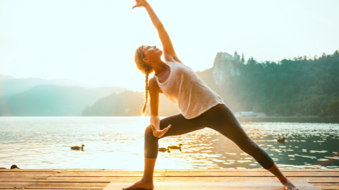 woman practicing sun salutations outside
