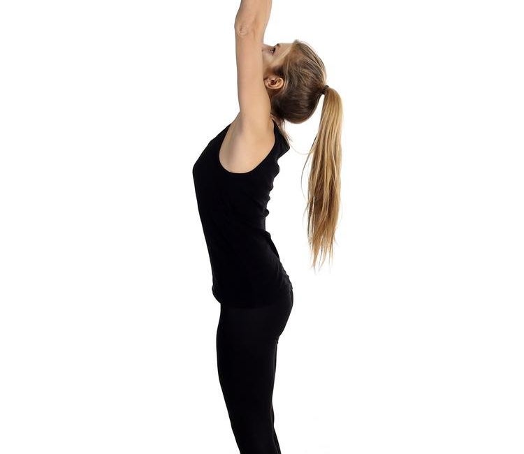 Woman in raised arms pose, reaching upwards