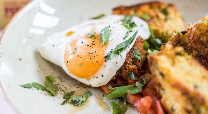 Fried egg on toast with fresh herbs and tomatoes