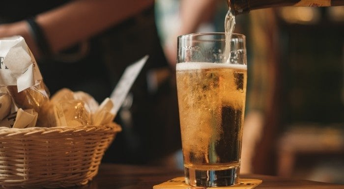Glass of lager being poured at a bar