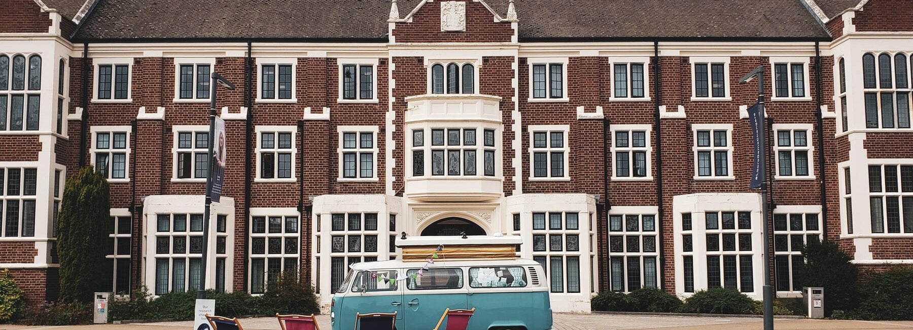Loughborough University building with a camper van and deckchairs on the lawn