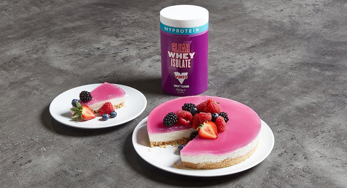 Vimto layered protein cheesecake with berries next to a tub of Myprotein Clear Whey Isolate
