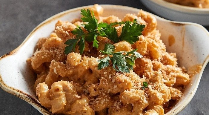 Bowl of vegan mac and cheese topped with parsley