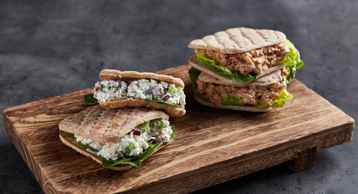 Protein-packed tuna and chicken salad sandwiches in flatbread thins on a wooden board