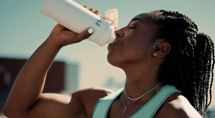 Woman drinking from a water bottle after an outdoor workout