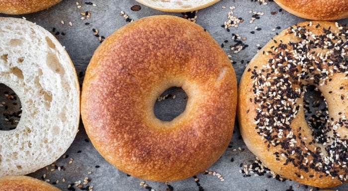 Plain and seeded bagels on a baking tray