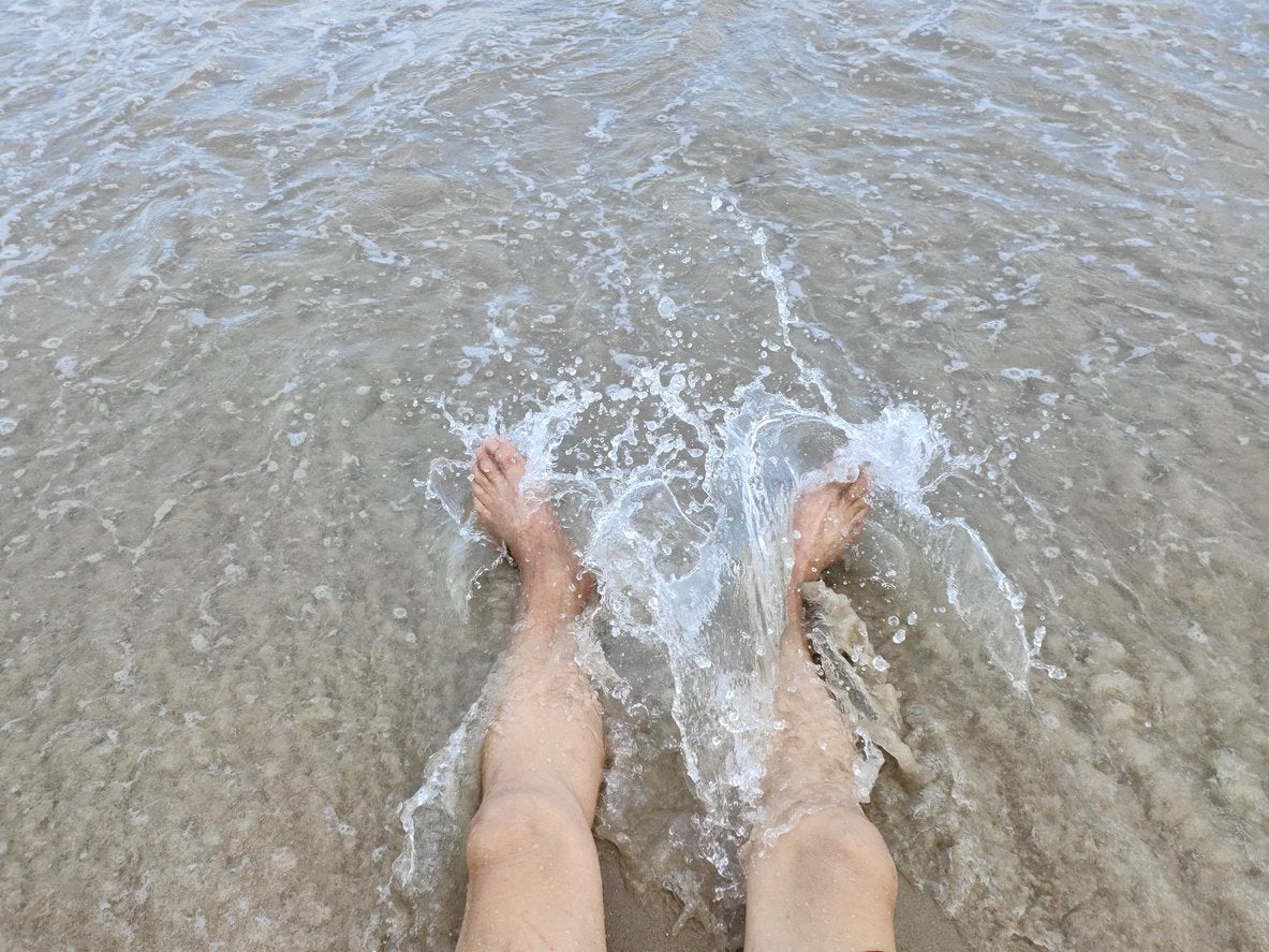 A man with his legs in the surf | Gillette UK