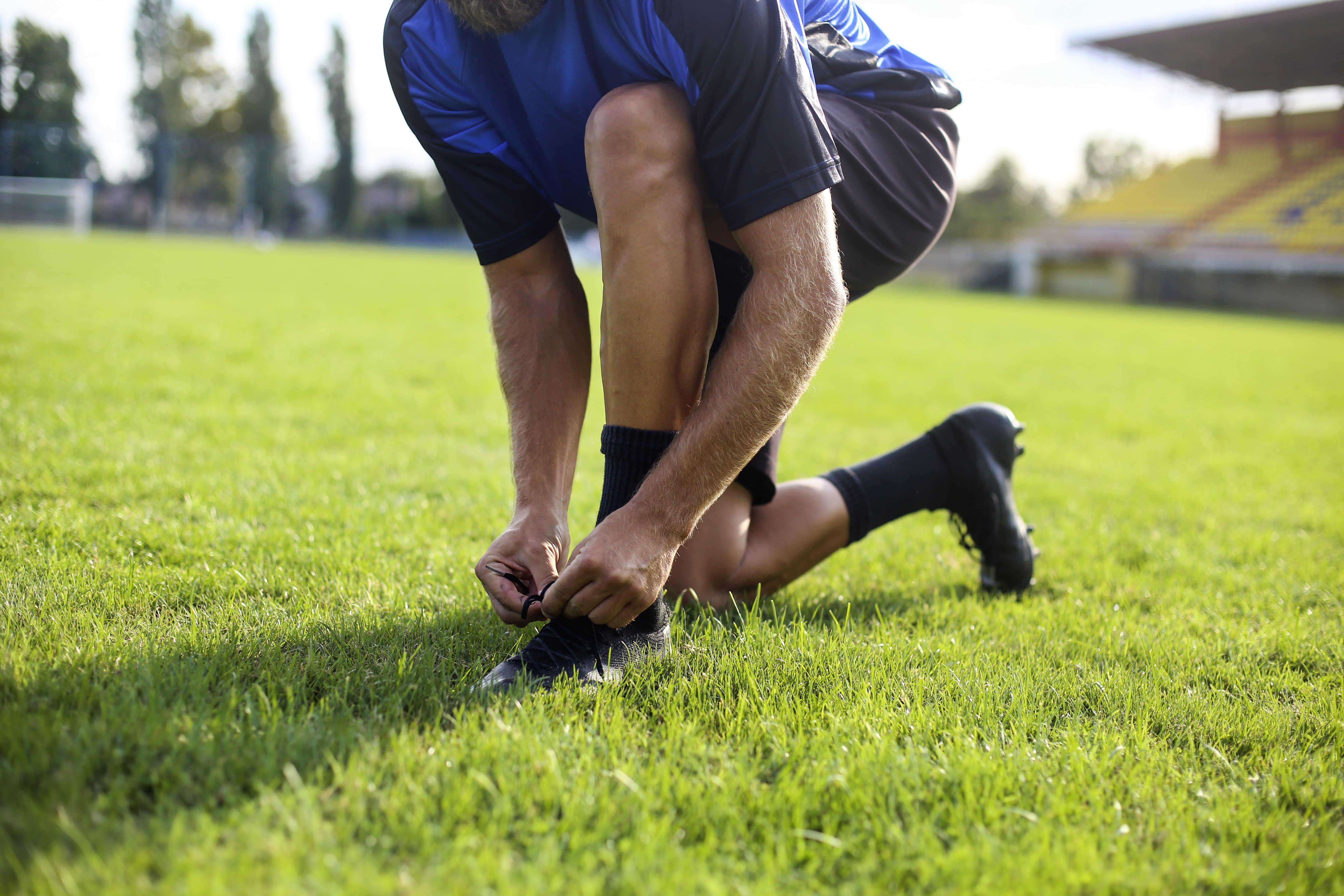 A man ties the laces on a football pitch | Gillette UK