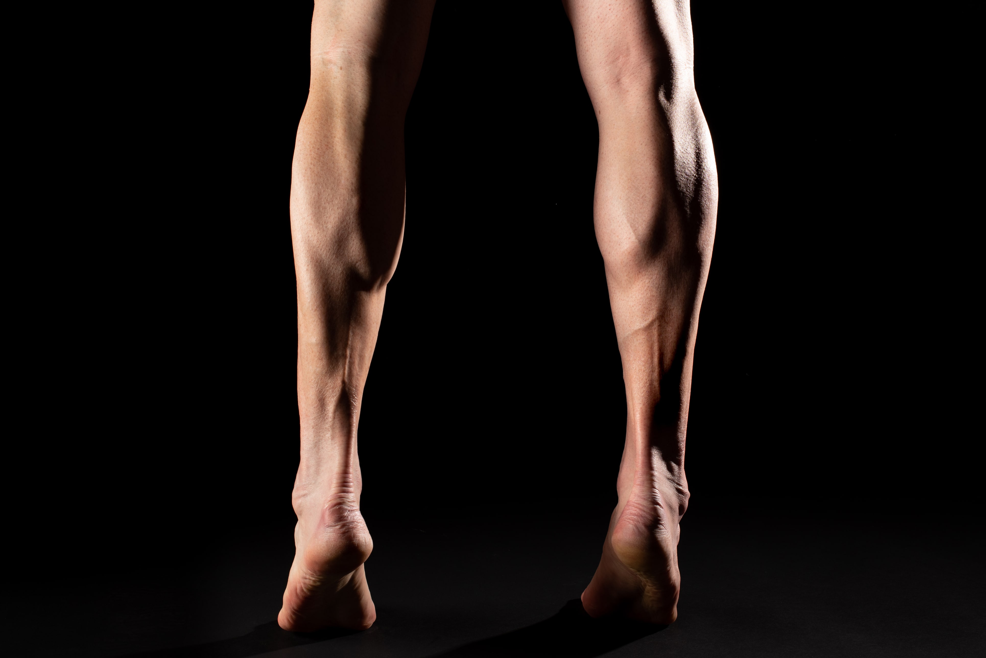 Dramatic shot of athletic legs against a black background | Gillette UK
