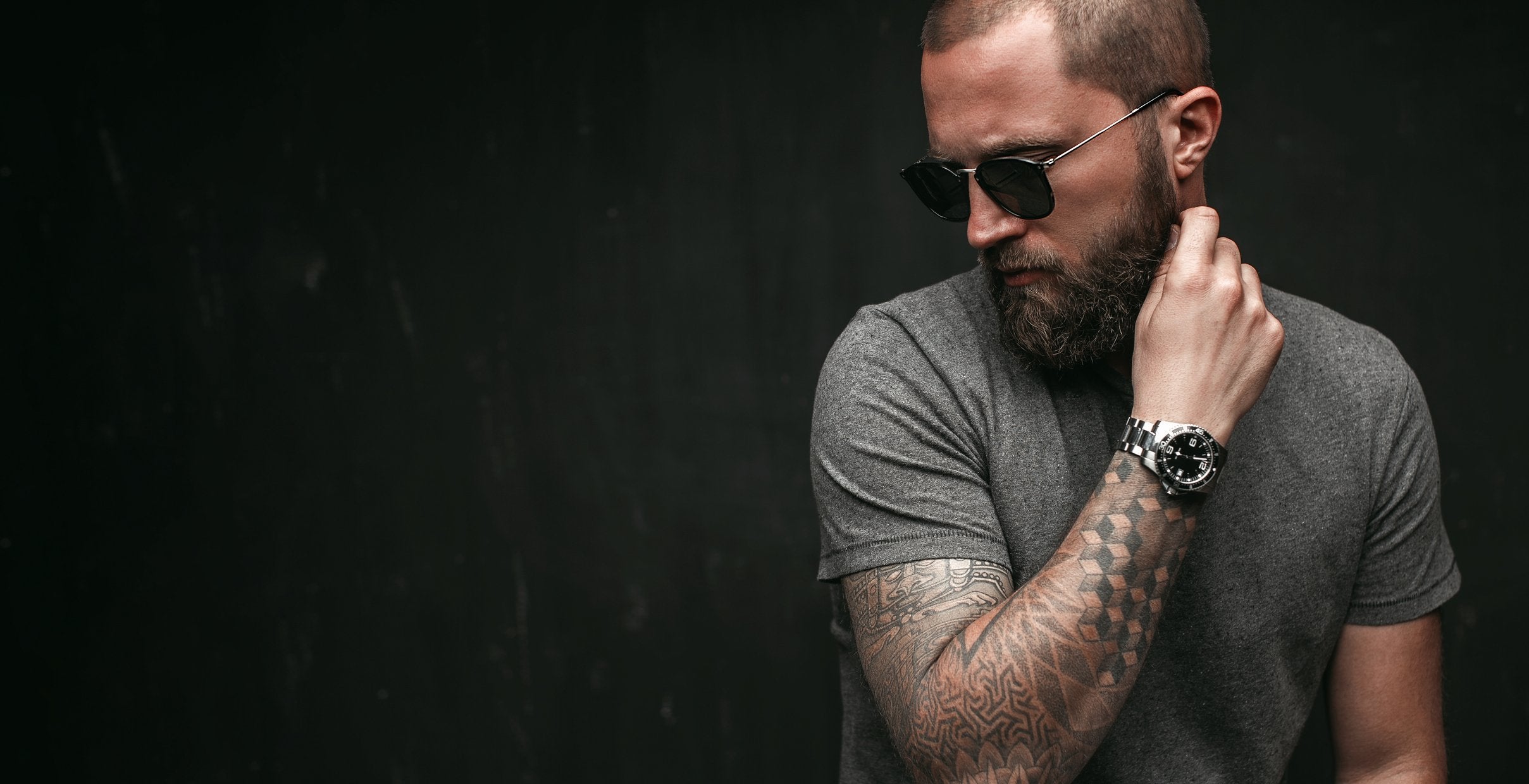 A tattooed man wearing sunglasses indoors | Gillette UK