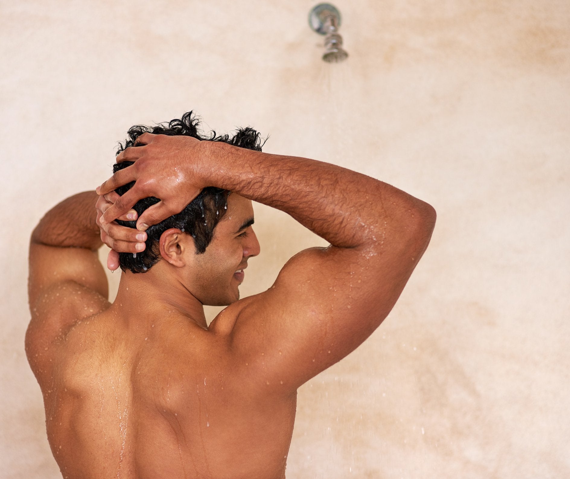 A man takes a warm shower to prep his hair and skin before starting intimate grooming | Gillette UK