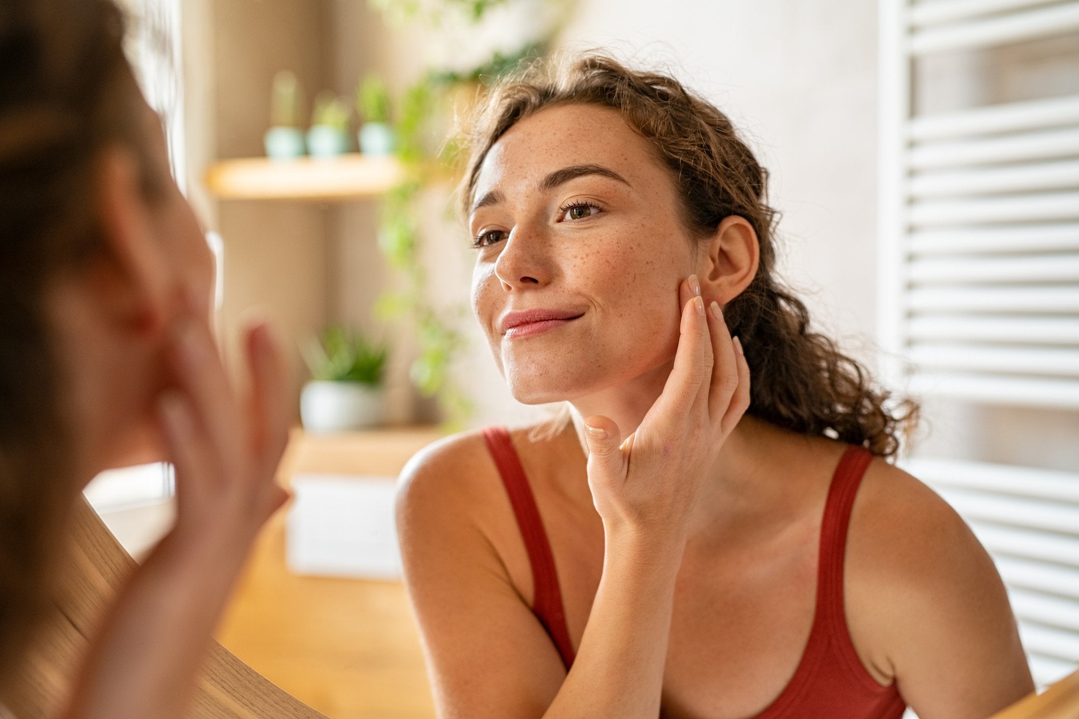 Woman looking at face in the mirror before dermaplaning at home | Gillette Venus UK