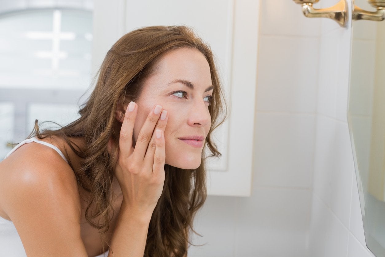 Side view of a woman examining her face in the mirror | Gillette Venus UK