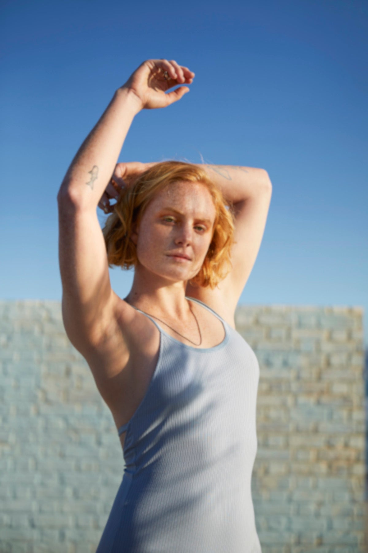 A woman wearing a lilac vest top raises her arms | Gillette Venus UK