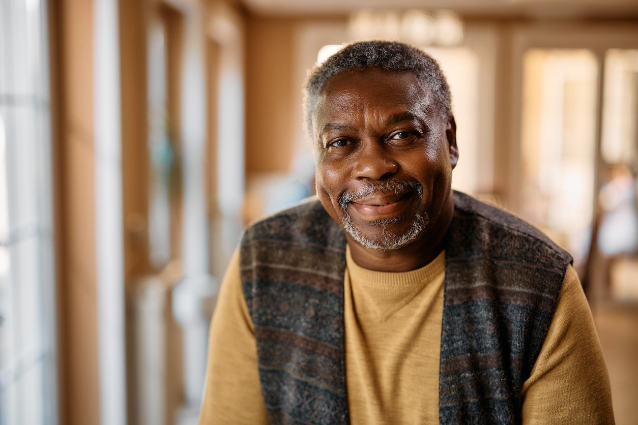 Man with short grey haircut smiling at the camera